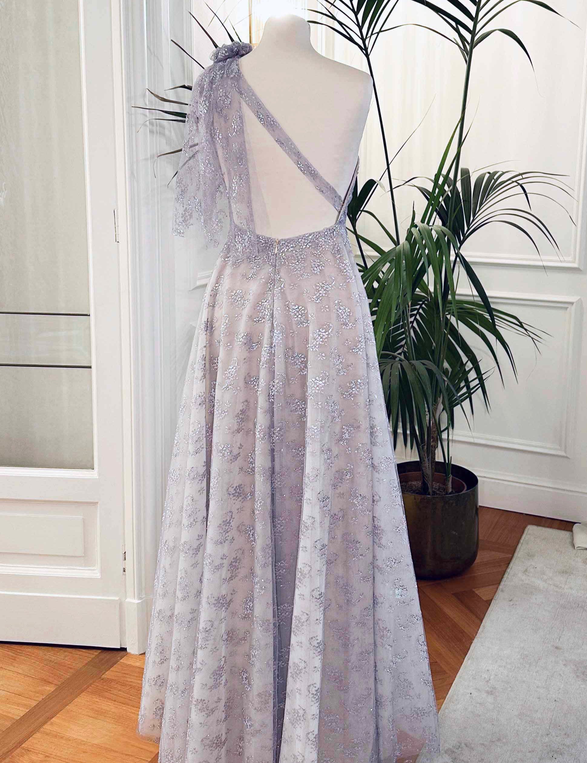 Abito da cerimonia asimmetrico in pizzo laminato glicine con drappeggio laterale e scollo profondo sulla schiena – modello Iris Sofia Provera