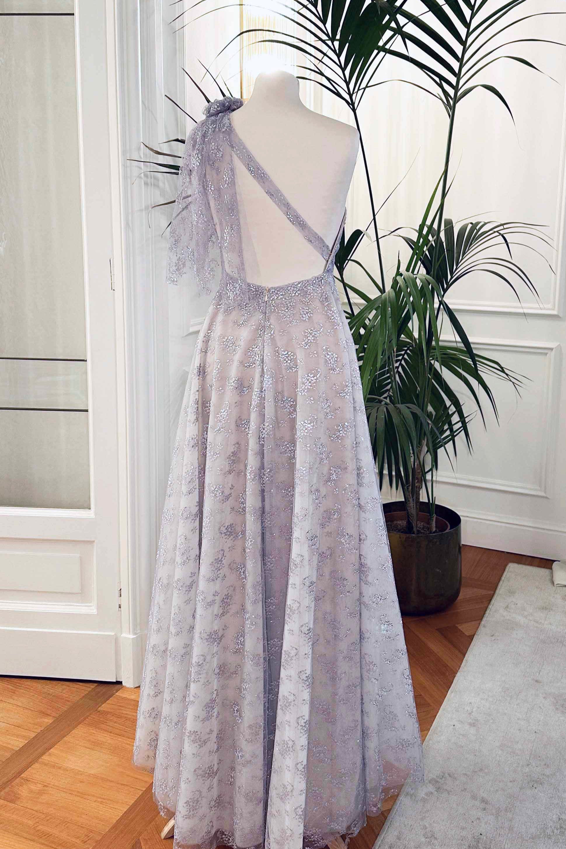 Abito da cerimonia asimmetrico in pizzo laminato glicine con drappeggio laterale e scollo profondo sulla schiena – modello Iris Sofia Provera