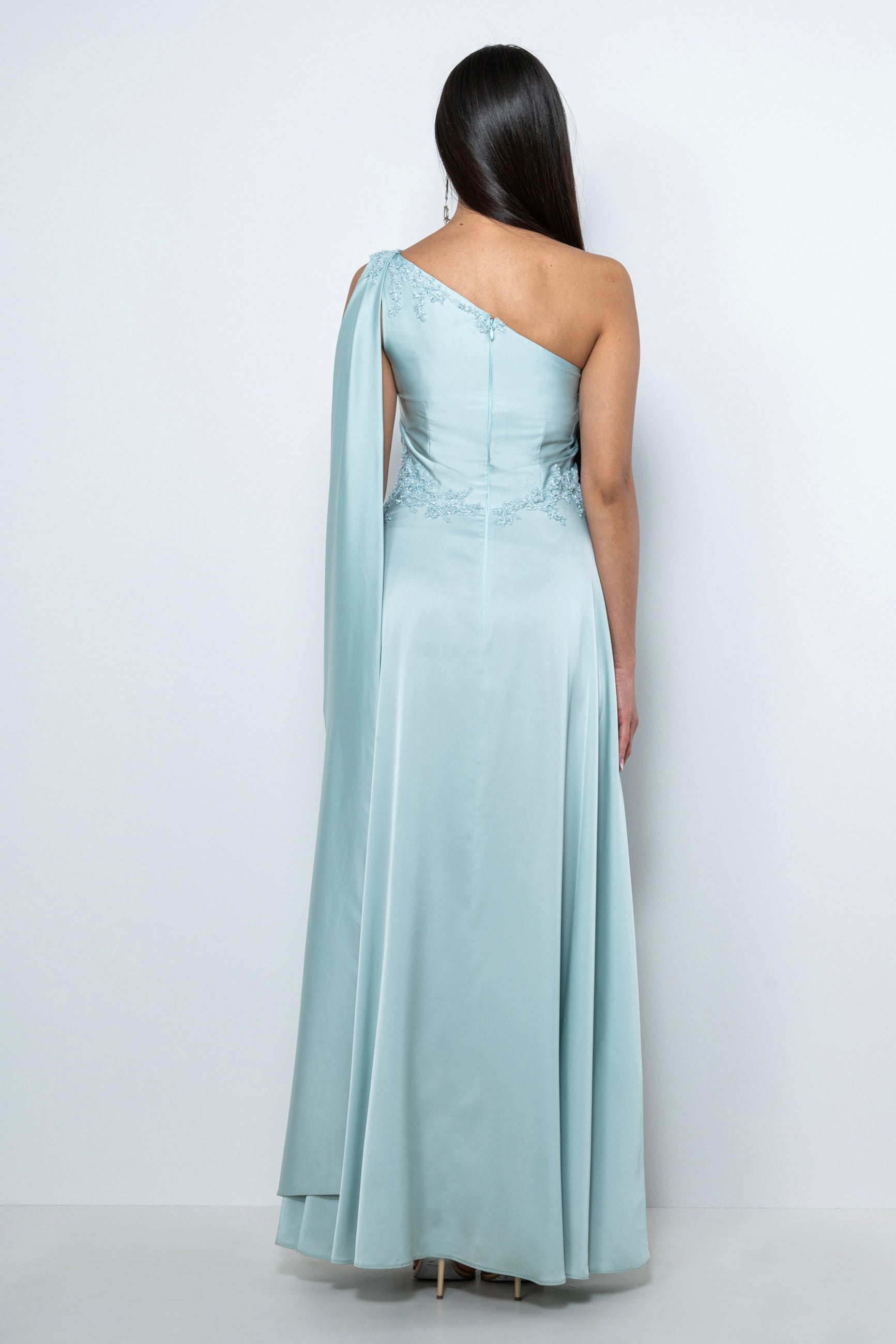 Abito cerimonia lungo in satin color menta "Phoebe" con scollo asimmetrico e ricami artigianali, disponibile a noleggio.